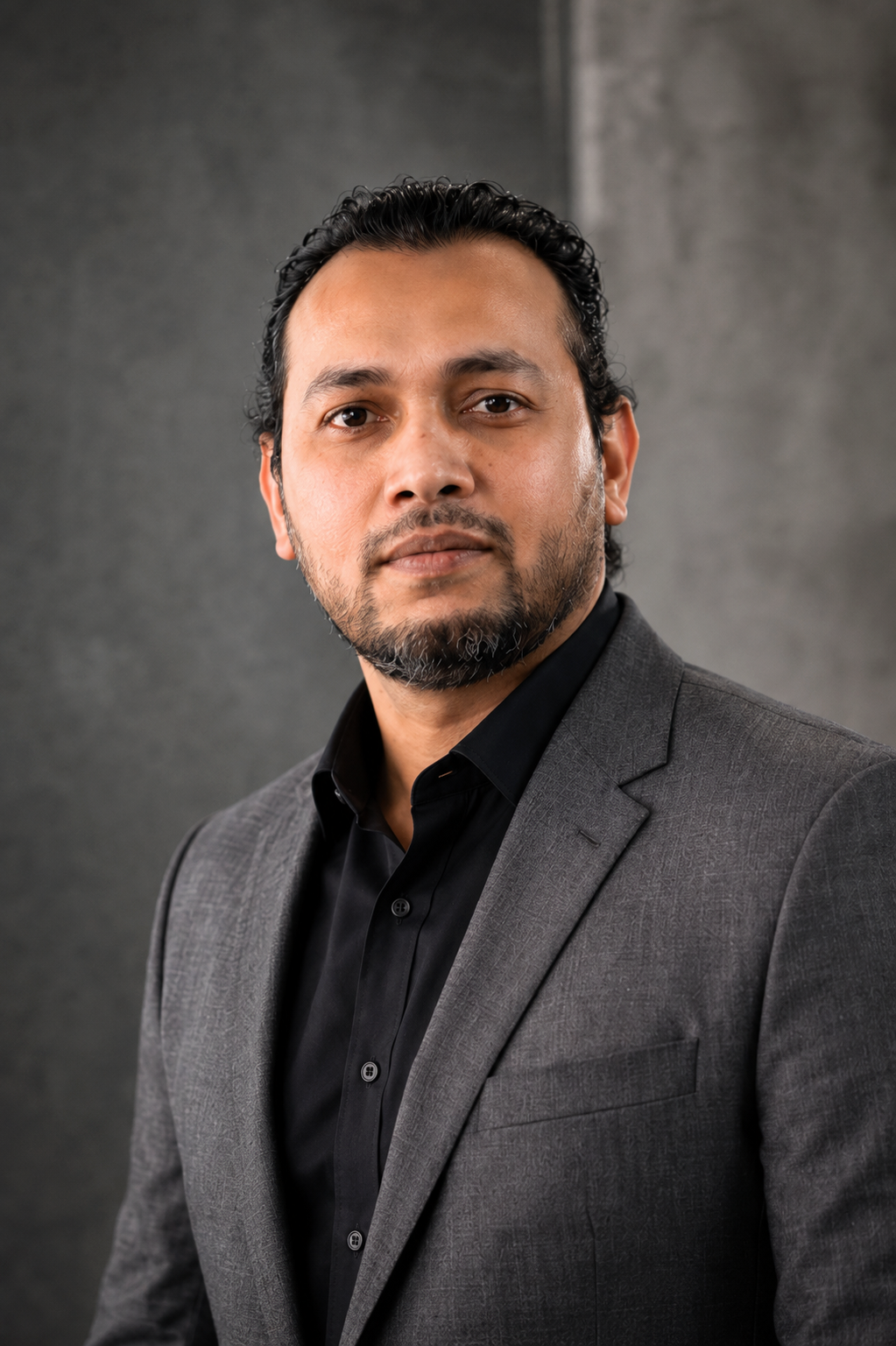 Ainul Bashar wearing a dark jacket and black shirt